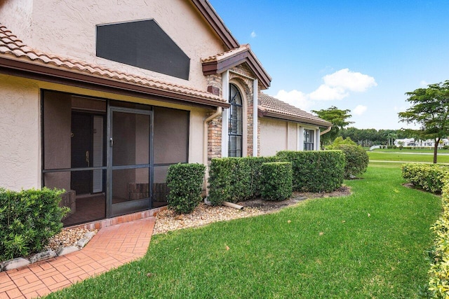 doorway to property featuring a lawn