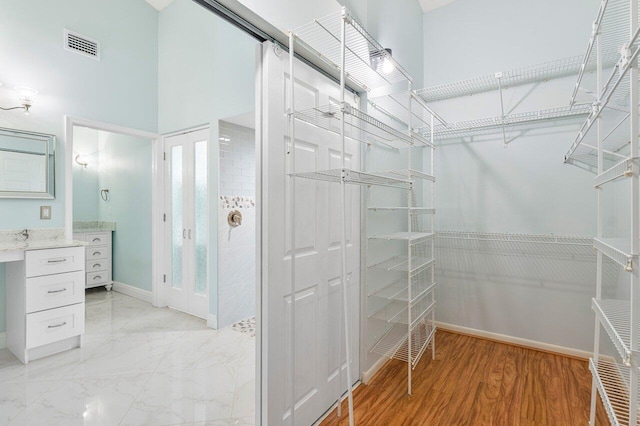 walk in closet featuring a towering ceiling and light wood-type flooring