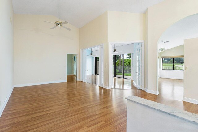 unfurnished living room featuring hardwood / wood-style floors and high vaulted ceiling