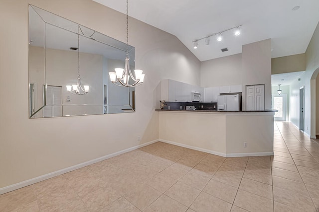 kitchen with a notable chandelier, white cabinetry, kitchen peninsula, hanging light fixtures, and white appliances