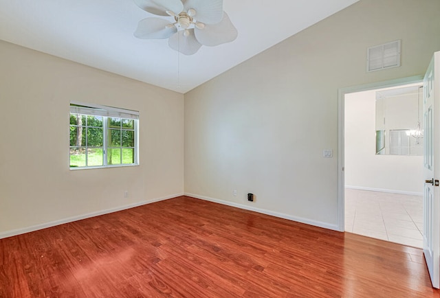 spare room with vaulted ceiling, light hardwood / wood-style floors, and ceiling fan