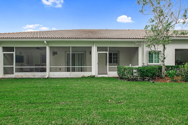 rear view of house with a sunroom and a lawn