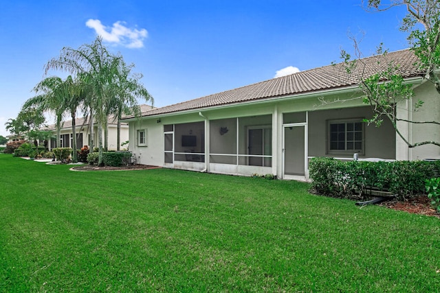 back of house with a lawn and a sunroom