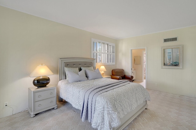 bedroom featuring light colored carpet and ensuite bathroom