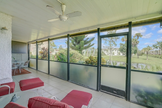 sunroom featuring a water view and ceiling fan