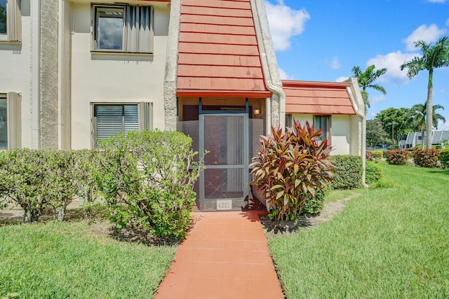 entrance to property featuring a lawn