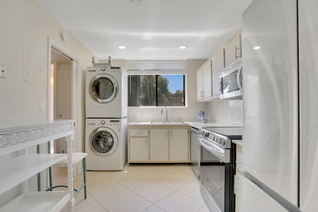 laundry area featuring stacked washer / drying machine, light tile patterned flooring, and sink