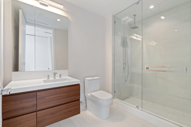 bathroom featuring an enclosed shower, vanity, and toilet