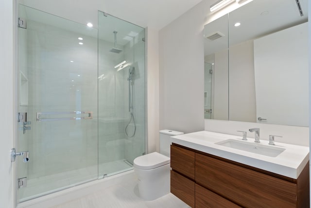 bathroom with walk in shower, vanity, and toilet