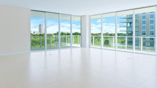 tiled empty room featuring a wall of windows