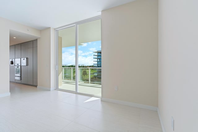 spare room with light tile patterned floors and expansive windows