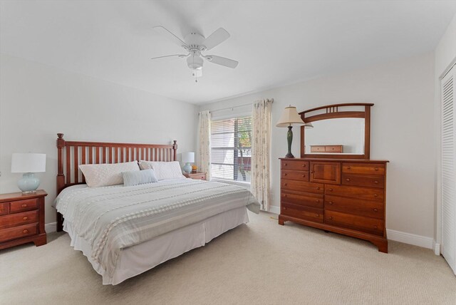 carpeted bedroom with ceiling fan and a closet