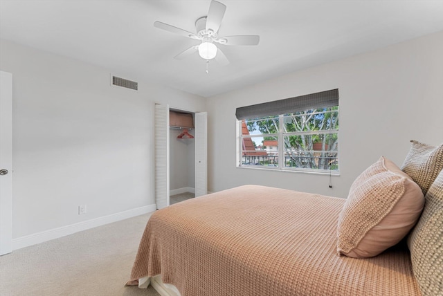 carpeted bedroom with ceiling fan and a closet