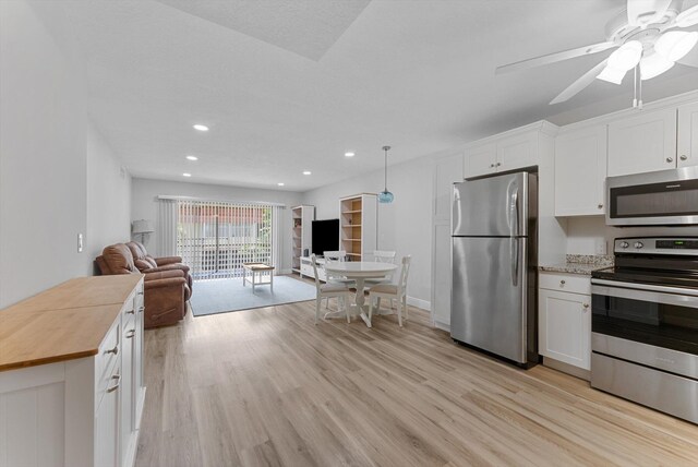 kitchen featuring stainless steel appliances, white cabinetry, and ceiling fan