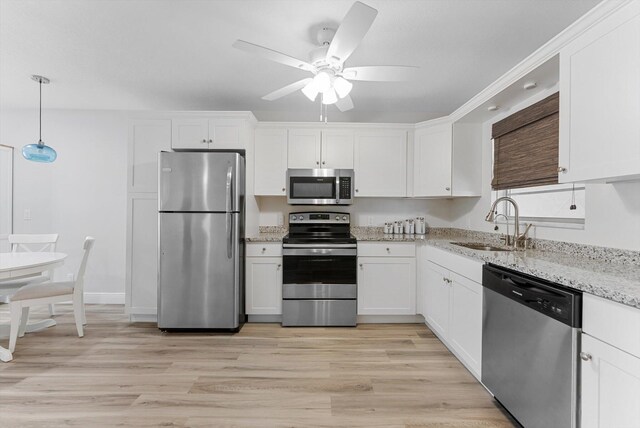 kitchen with light hardwood / wood-style floors, sink, white cabinets, appliances with stainless steel finishes, and ceiling fan