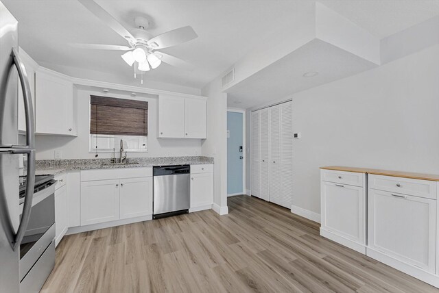 kitchen with ceiling fan, sink, light hardwood / wood-style flooring, white cabinetry, and stainless steel appliances