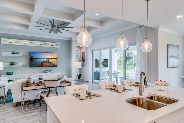 kitchen featuring pendant lighting, ceiling fan, coffered ceiling, and sink