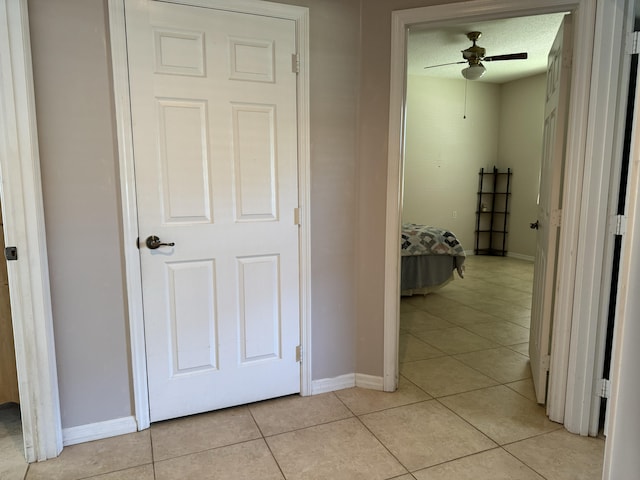 hallway with a textured ceiling and light tile patterned floors