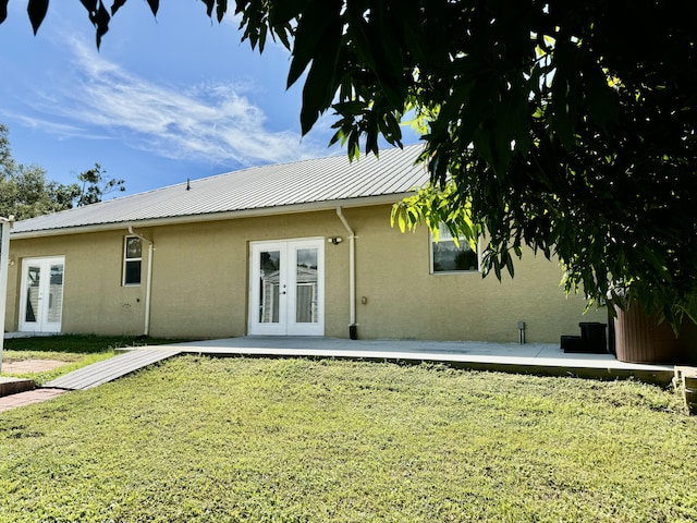 back of property featuring a yard, french doors, and a patio area