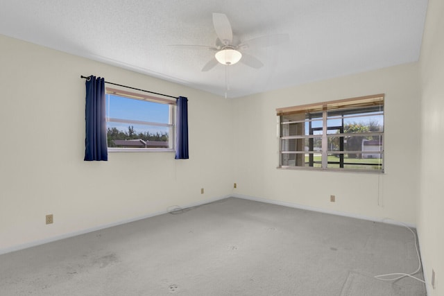 carpeted spare room with a textured ceiling and ceiling fan