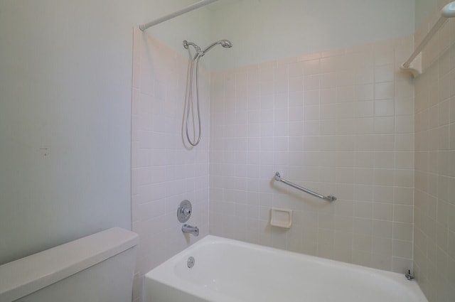 bathroom with toilet and tiled shower / bath