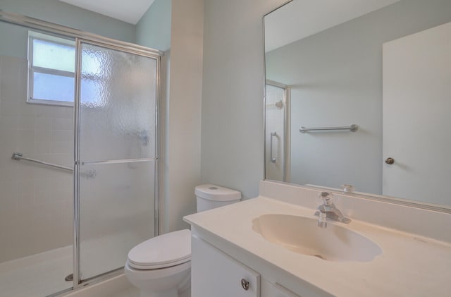 bathroom featuring vanity, an enclosed shower, and toilet