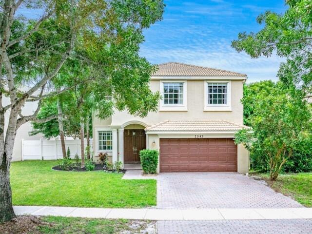 view of front of property with a front yard and a garage