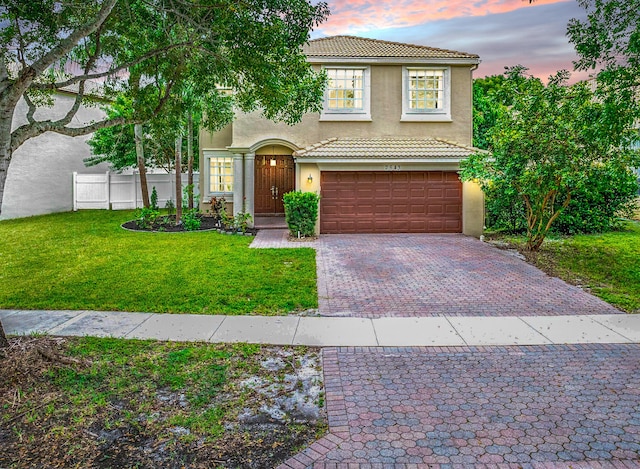 view of front of property featuring a garage and a lawn