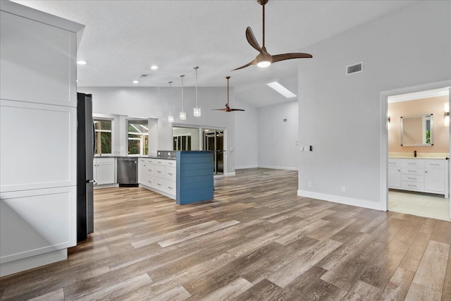 kitchen with fridge, light hardwood / wood-style flooring, high vaulted ceiling, white cabinets, and stainless steel dishwasher