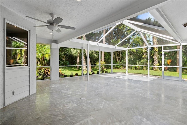 unfurnished sunroom with ceiling fan, lofted ceiling, and plenty of natural light