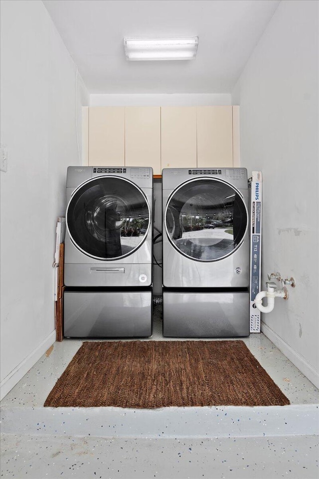 clothes washing area with washer and clothes dryer