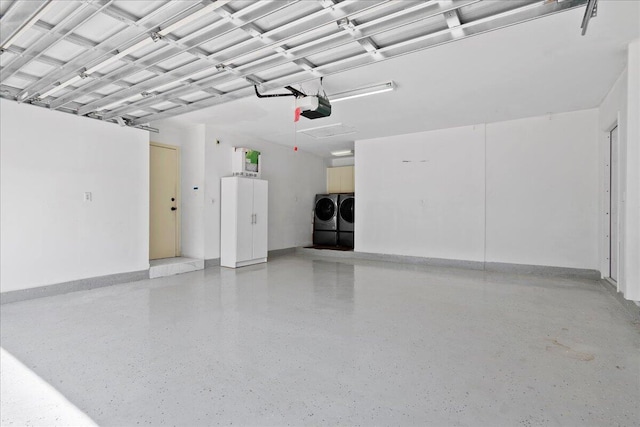 garage with a garage door opener and independent washer and dryer