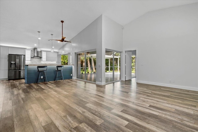 unfurnished living room featuring light wood-type flooring and high vaulted ceiling