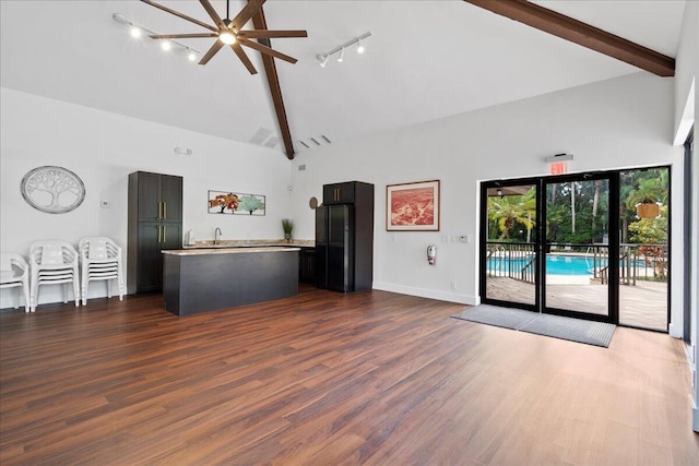 unfurnished living room with dark hardwood / wood-style floors, track lighting, and high vaulted ceiling