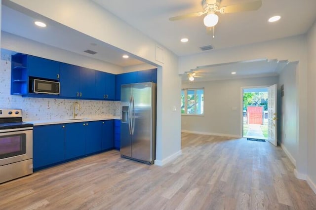 kitchen with ceiling fan, stainless steel appliances, blue cabinets, and light hardwood / wood-style flooring