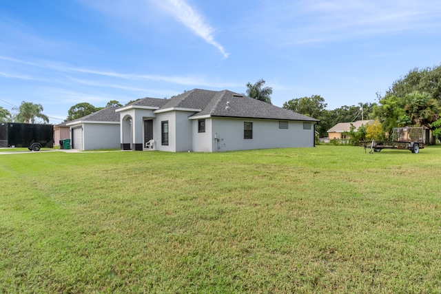 back of property featuring a lawn and a garage