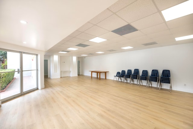 interior space featuring a drop ceiling and light hardwood / wood-style floors