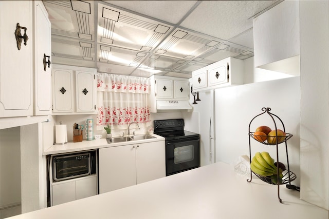 kitchen with black appliances, sink, and white cabinets