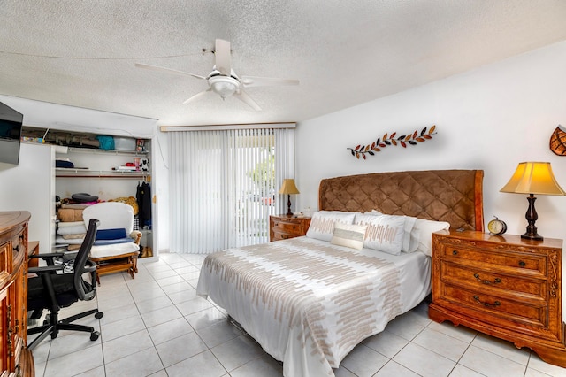 tiled bedroom with a textured ceiling and ceiling fan