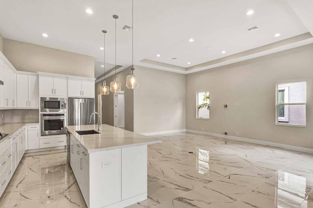 kitchen featuring white cabinetry, appliances with stainless steel finishes, sink, and a center island with sink