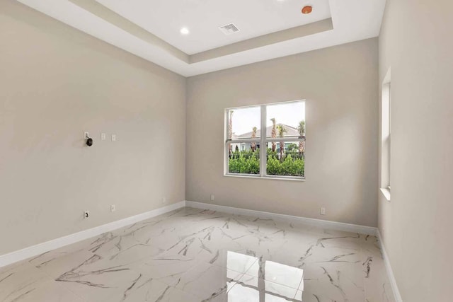 unfurnished room with a tray ceiling