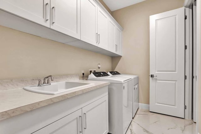 washroom featuring cabinets, sink, and washing machine and dryer