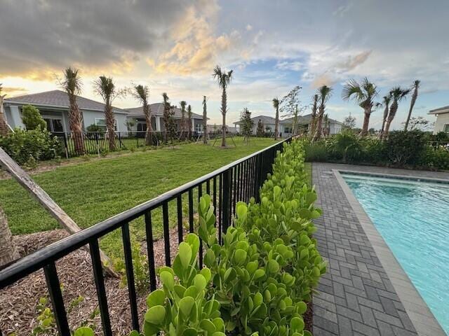 view of pool featuring a lawn