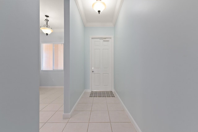 hall with ornamental molding and light tile patterned floors