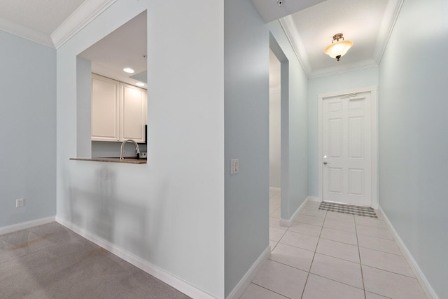 hall featuring light tile patterned flooring and ornamental molding