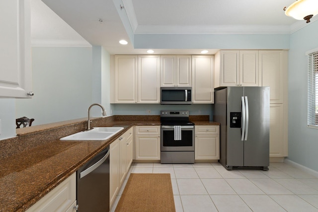 kitchen featuring light tile patterned floors, sink, appliances with stainless steel finishes, dark stone counters, and crown molding