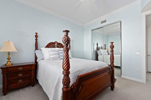 bedroom featuring light carpet, a closet, ceiling fan, and crown molding