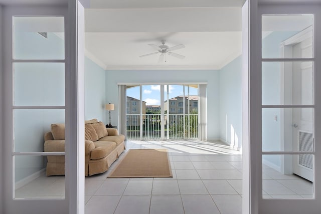 unfurnished living room featuring ornamental molding, ceiling fan, and light tile patterned flooring