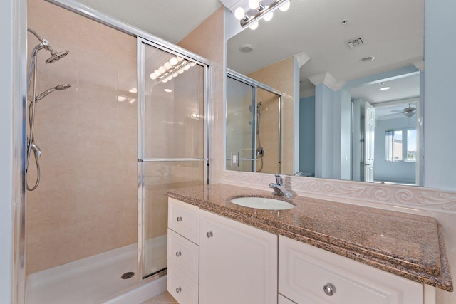 bathroom with ceiling fan, walk in shower, and vanity