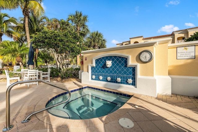 view of swimming pool with a hot tub and a patio area